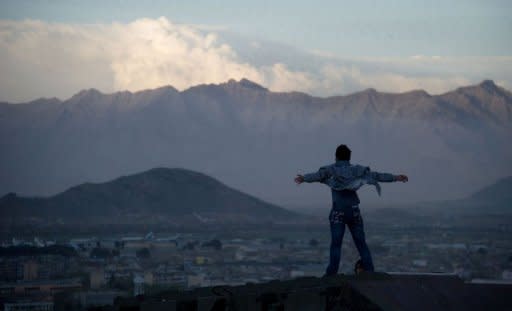 An Afghan boy poses on a old Russian tank as his friend takes his photograph from below on a hill overlooking Kabul on April 10, 2012. Anger over the murderous rampage last month by a US soldier who allegedly killed 17 Afghan villagers has complicated talks over immunity for US soliders in local courts