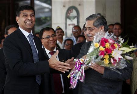 Raghuram Rajan (L), newly appointed governor of Reserve Bank of India (RBI) receives a bouquet from RBI deputy governor K C Chakrabarty after his arrival at the bank's headquarters in Mumbai September 4, 2013. REUTERS/Danish Siddiqui