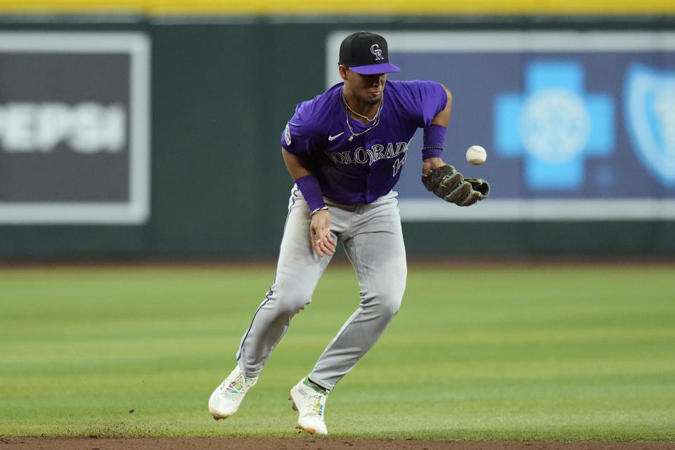 Colorado Rockies shortstop Ezequiel Tovar is unable to make a play on an infield single hit by Arizona Diamondbacks' Joc Pederson during the sixth inning of a baseball game Friday, March 29, 2024, in Phoenix. (AP Photo/Ross D. Franklin)