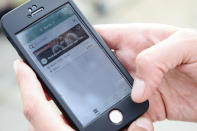 In this Tuesday, May 21, 2019 photo, Annekathrin Fiesinger shows how to use the food sharing app 'Too Good To Go' to reduce food waste, during an interview with the Associated Press in Berlin. In Germany, growing numbers of people use modern technology such as phone apps to help reduce food waste. In an effort to cut down on climate-wrecking carbon dioxide emissions created by food waste, they build online communities to share food before throwing it away. (AP Photo/Markus Schreiber)