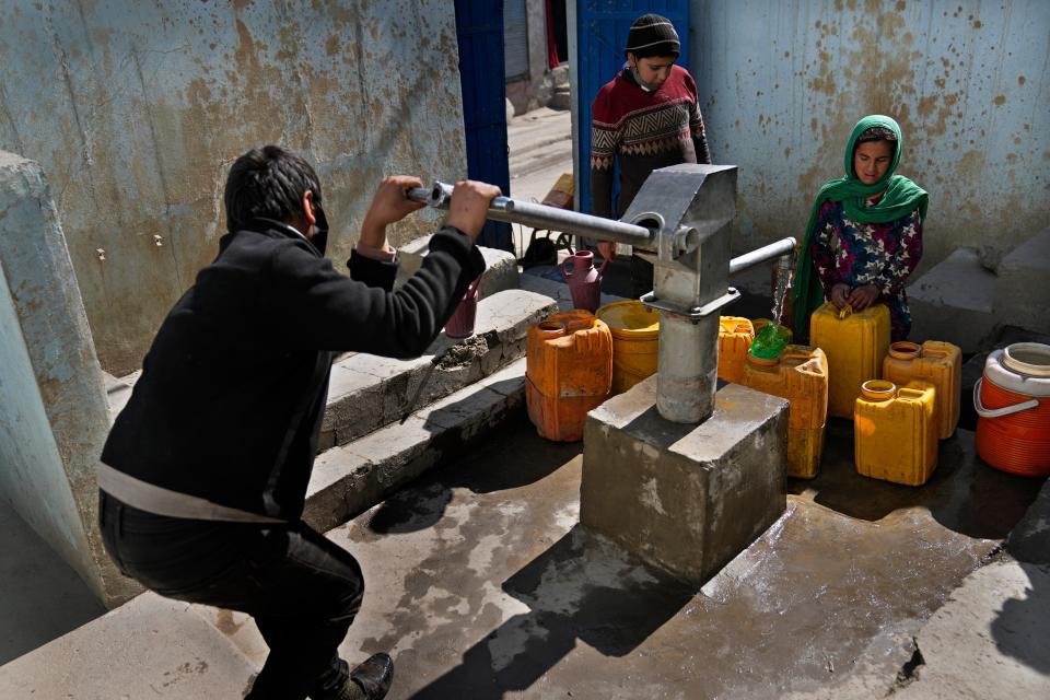 Afghans fill containers with water from a well at a mosque in Kabul, Afghanistan, Sunday, Feb. 20, 2022. (AP Photo/Hussein Malla) ORG XMIT: XHM106