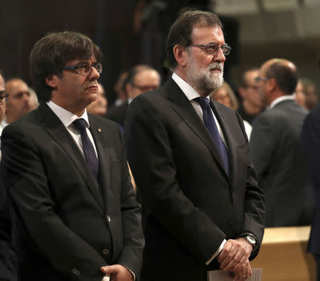 President of the Generalitat of Catalonia Carles Puigdemont and Spanish Prime Minister Mariano Rajoy are seen at a High mass celebrated in memory of the victims of the van attack at Las Ramblas earlier this week, at the Basilica of the Sagrada Familia in Barcelona, Spain August 20, 2017. REUTERS/Sergio Barrenechea/Pool
