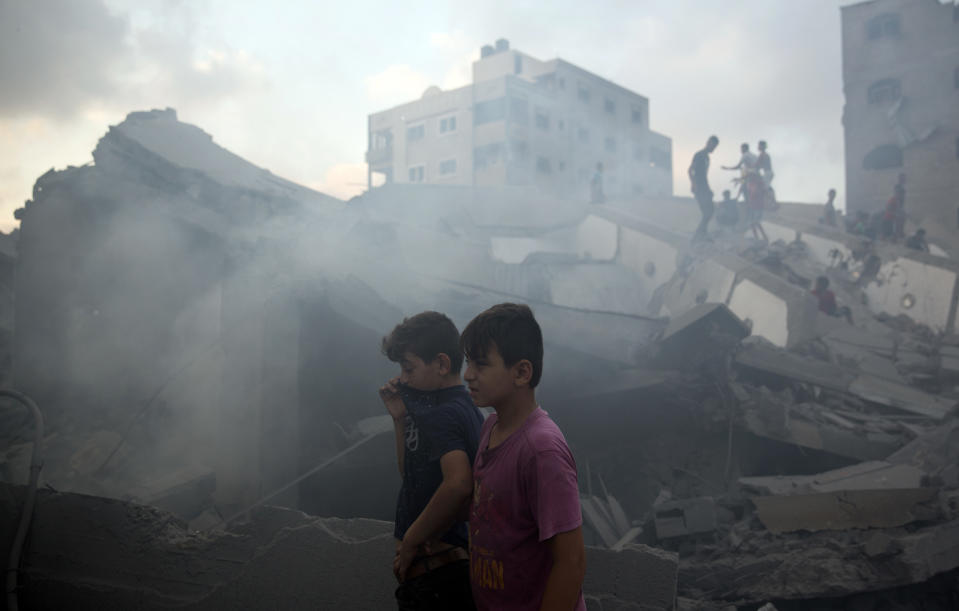 Palestinians inspect the damaged building of Said al-Mis'hal cultural center after it was hit bombed by an Israeli airstrike in Gaza City, Thursday, Aug. 9, 2018. (AP Photo/Khalil Hamra)