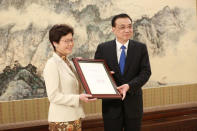 China's Premier Li Keqiang and Carrie Lam pose for pictures as Lam receives the Hong Kong's chief executive appointment certificate, in Beijing, China April 11, 2017. China Daily/via REUTERS