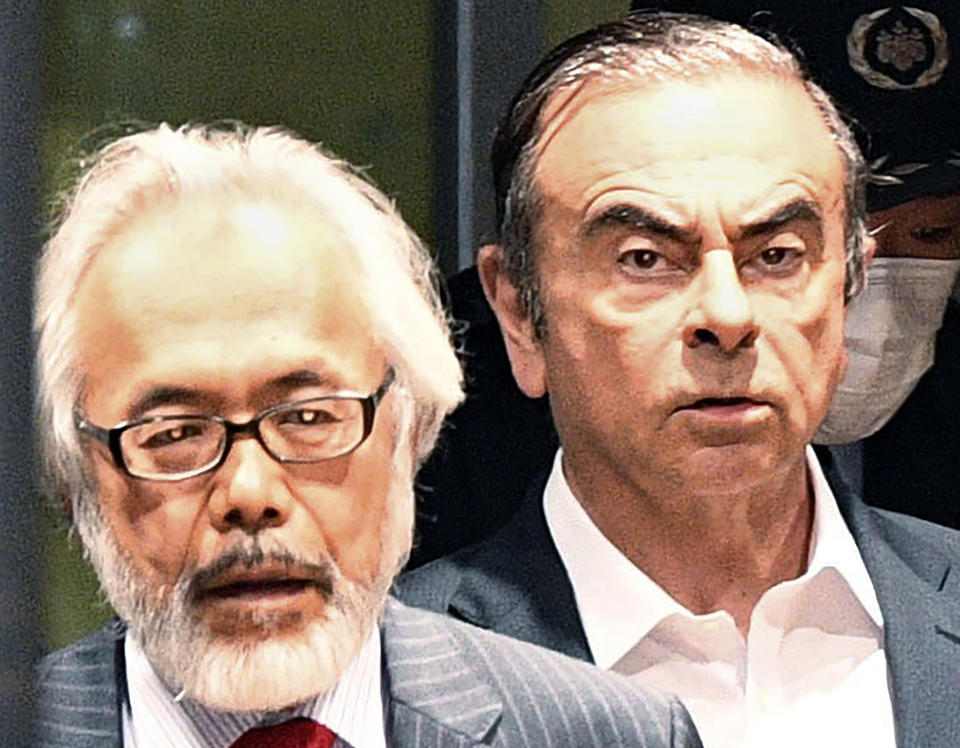 FILE - In this April 25, 2019, file photo, former Nissan Chairman Carlos Ghosn, right, walks behind his lawyer Takashi Takano as he leaves the Tokyo Detention Center in Tokyo. Takano said Saturday, Jan. 4, 2020, he felt outraged and betrayed by his client's escape from Japan to Lebanon, but also expressed an understanding for his feelings of not being able to get a fair trial. "My anger gradually began to turn to something else," Takano wrote in his blog post. (Kyodo News via AP, File)/Kyodo News via AP)