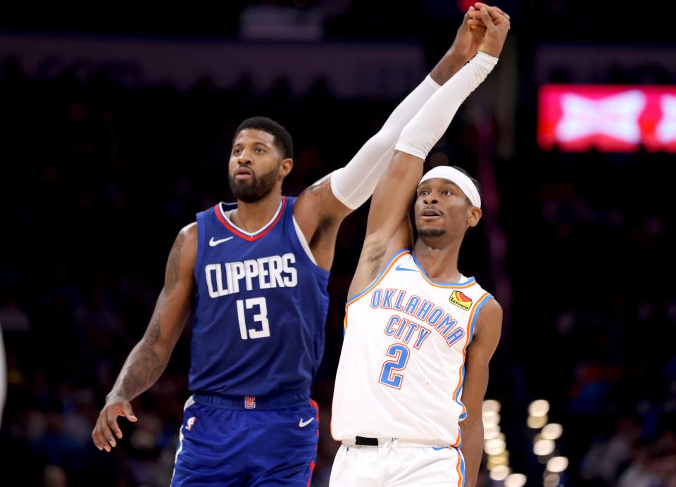 Thunder guard Shai Gilgeous-Alexander (2) watches his basket fall as Clippers forward Paul George (13) defends on Thursday.