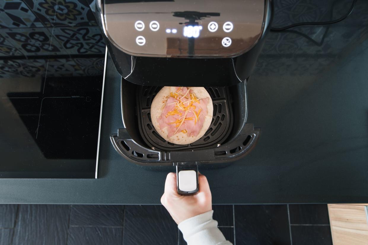 Preparing a ham and cheese tortilla in an air fryer