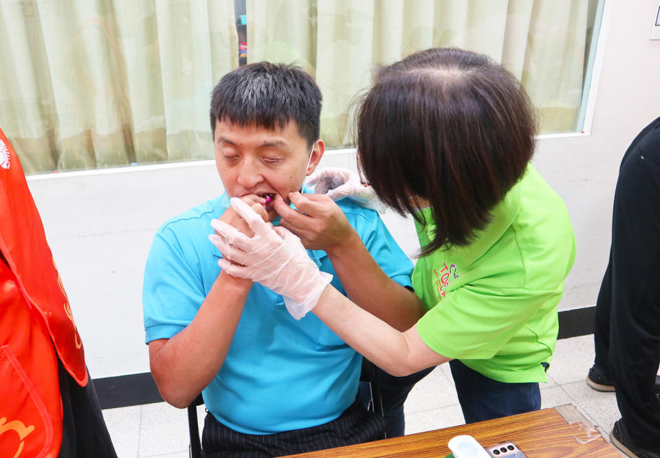 在現場人員專業指導下，協助伊甸視障朋友操作牙縫清潔步驟，做好牙口護理。