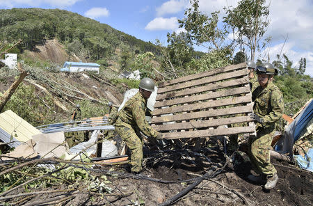 Members of the Japan Self-Defense Forces (JSDF) search for survivors from a house damaged by a landslide caused by an earthquake in Atsuma town, Hokkaido, northern Japan, in this photo taken by Kyodo September 6, 2018. Mandatory credit Kyodo/via REUTERS