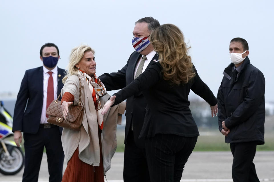 U.S. Secretary of State Mike Pompeo, center, and his wife Susan, right, embrace U.S. Ambassador to France Jamie McCourt, left, after stepping off a plane at Paris Le Bourget Airport, Saturday, Nov. 14, 2020, in Le Bourget, France. Pompeo is beginning a 10-day trip to Europe and the Middle East. (AP Photo/Patrick Semansky, Pool)