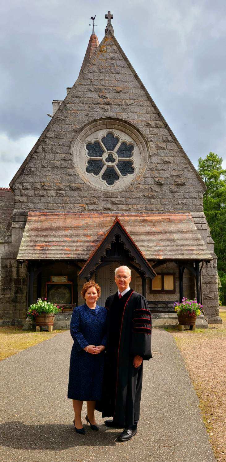 Rev. Dr. Richard Gibbons of First Presbyterian Church Greenville poses alongside his wife Ruth in front of Crathie Parish Church in Crathie, Aberdeenshire, Scotland.