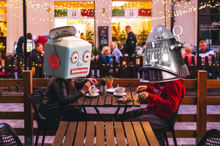 Photo illustration of two friends with robot heads having dinner