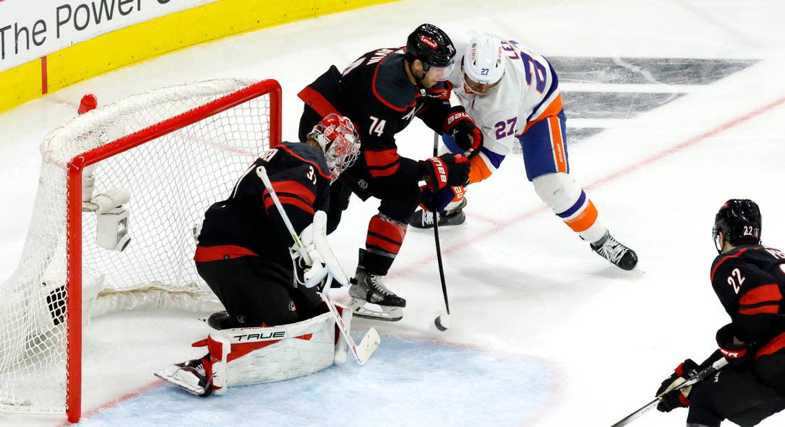 Carolina goaltender Frederik Andersen (31) makes the save as New York left wing Anders Lee (27) shoots during the second period of the Hurricanes game against the Islanders in the first round of the Stanley Cup playoffs at PNC Arena in Raleigh, N.C., Saturday, April 20, 2024. Carolina defenseman Jaccob Slavin (74) defends Lee. Ethan Hyman/ehyman@newsobserver.com