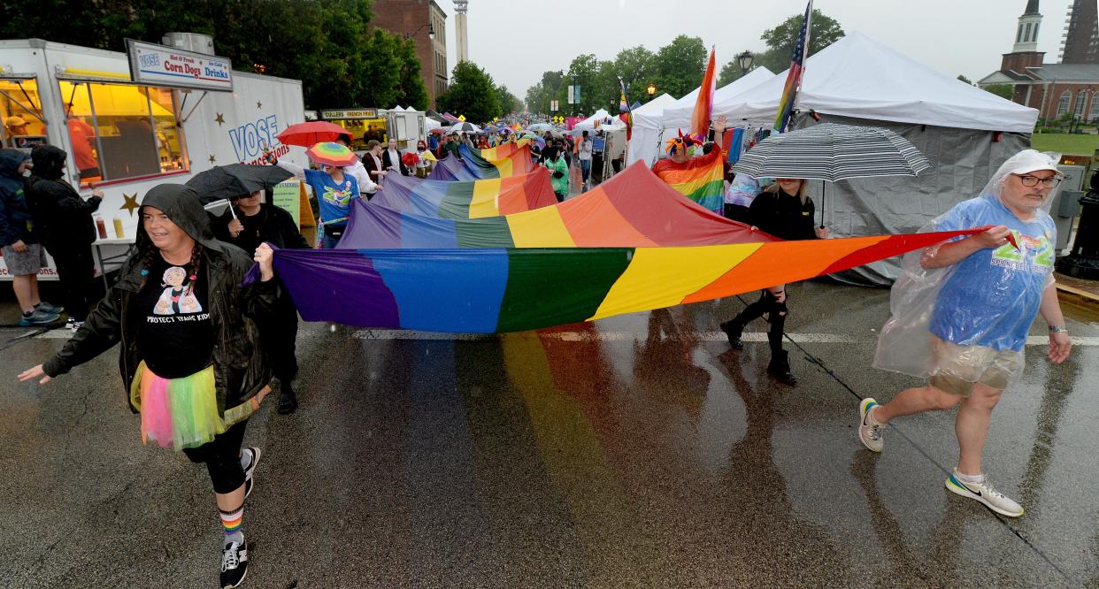 A group carries the LGBTQIA+ flag to lead off the PrideFest parade in Springfield Saturday. Thousands of people braved heavy rains early in the day to attend the festivities. [Thomas J. Turney/The State Journal-Register]