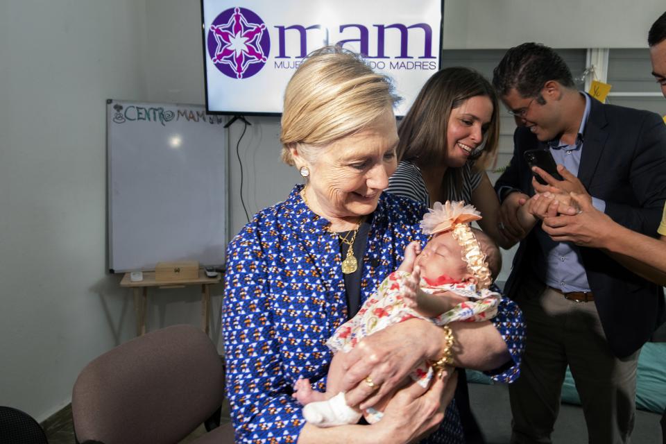 Clinton with an infant who received services from Centro MAM