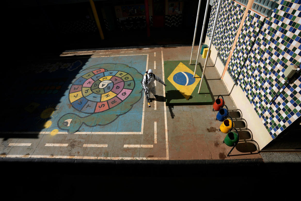 A worker fumigates a public school playground. (Eraldo Peres / AP)