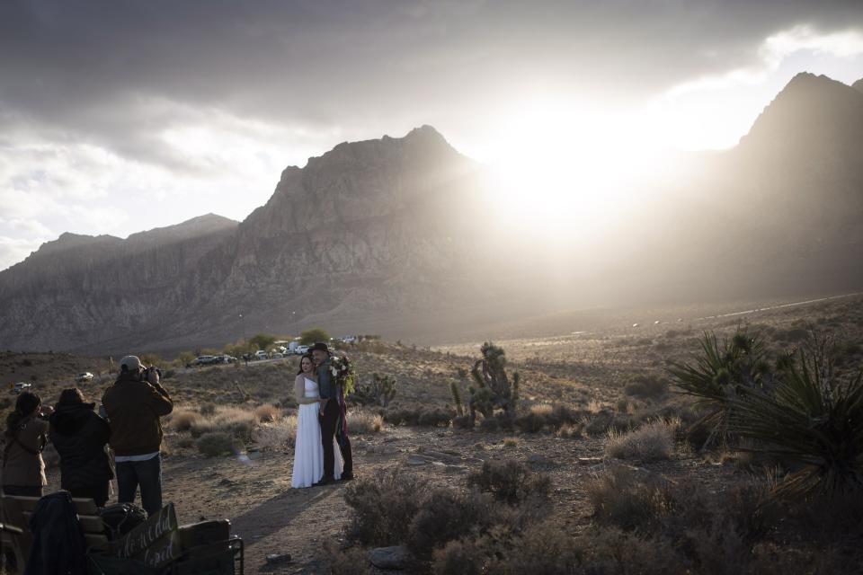 A couple poses for wedding photographs in the Red Rock National Conservation Area near Las Vegas, Sunday, Nov. 8, 2020. (AP Photo/Wong Maye-E)