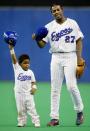 FILE - Montreal Expos' Vladimir Guerrero and his son Vladimir Jr. tip their caps to the crowd after Guerrero struck out in the eighth inning against Cincinnati Reds pitcher Joey Hamilton Sunday, Sept. 29, 2002 in Montreal. In all, more than two dozen major league offspring are on AL or NL rosters this year. The Blue Jays alone have three, including the sons of Hall of Famers Craig Biggio (Cavan) and Vladimir Guerrero (Vlad Jr.), along with Bo Bichette, whose father, Dante, was a four-time All-Star with the Rockies. (AP Photo/Paul Chiasson)