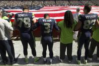 <p>Seattle Seahawks offensive tackle Bradley Sowell (78), left, quarterback Russell Wilson (3) and tight end Luke Willson (82) join arms during the National Anthem before the start of a game against the Miami Dolphins at CenturyLink Field. Mandatory Credit: Troy Wayrynen-USA TODAY Sports </p>