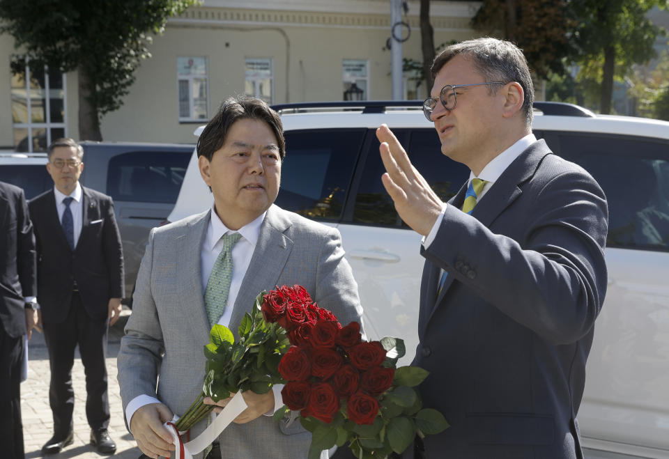 Ukraine's Foreign Minister Dmytro Kuleba, right, and his Japanese counterpart Yoshimasa Hayashi pay a visit to the Memory Wall of Fallen Defenders of Ukraine in Kyiv, Ukraine, Saturday, Sept. 9, 2023. Japanese Foreign Minister Hayashi arrived in Ukraine's capital for an unannounced visit where he will meet with top Ukrainian officials. (Sergey Dolzhenko/pool via AP)