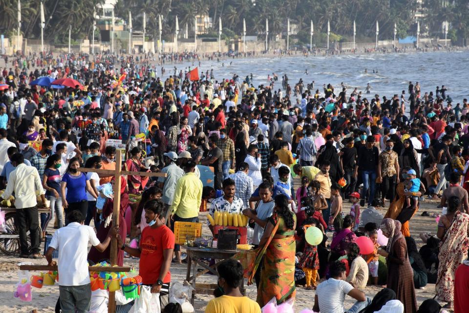 People are seen enjoying the warm weather at Juhu beach in...