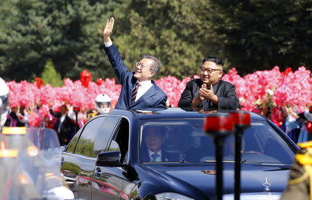 South Korean President Moon Jae-in and North Korean leader Kim Jong Un react during a car parade in Pyongyang, North Korea, September 18, 2018. Pyeongyang Press Corps/Pool via REUTERS