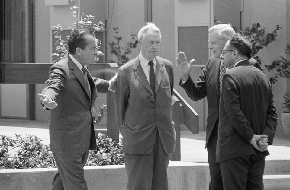 FILE - President Richard Nixon escorts Ambassador David K. E. Bruce from meeting at the Western White House after their meeting in San Clemente, Calif., July 4, 1970. Bruce was selected as new chief negotiator for the Paris peace talks. H. Alexis Johnson, under secretary of state and Dr. Henry Kessinger, right, the president's chief foreign policy advisor look on. (AP Photo, File)