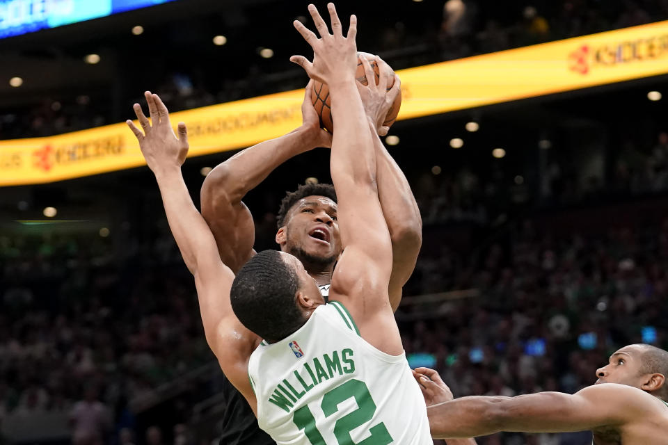 Milwaukee Bucks forward Giannis Antetokounmpo, center top, shoots at the basket as Boston Celtics forward Grant Williams (12) defends during the first half of Game 7 of an NBA basketball Eastern Conference semifinals playoff series, Sunday, May 15, 2022, in Boston. (AP Photo/Steven Senne)