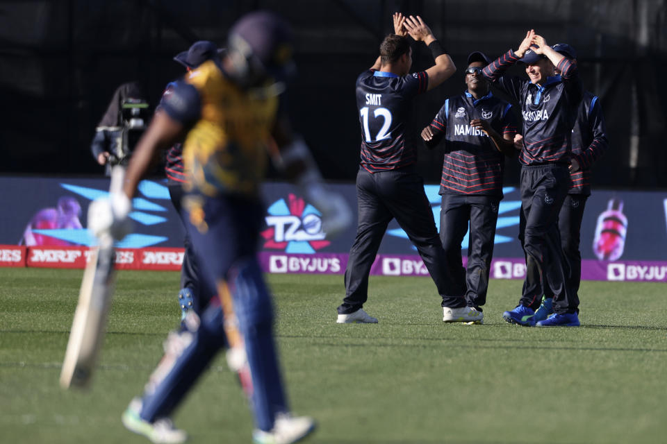 Namibia's JJ Smit, centre, celebrates with teammates after the wicket of Sri Lanka's Chamika Karunaratne, left, during their T20 World Cup Cricket match in Geelong, Australia, Sunday, Oct. 16, 2022. (AP Photo/Asanka Brendon Ratnayake)