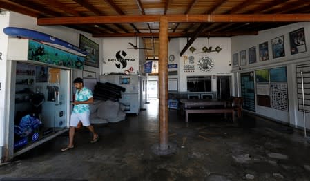 A staff member walks inside the emptry lobby at Pearl Divers, a diving school, at Unawatuna beach in Galle