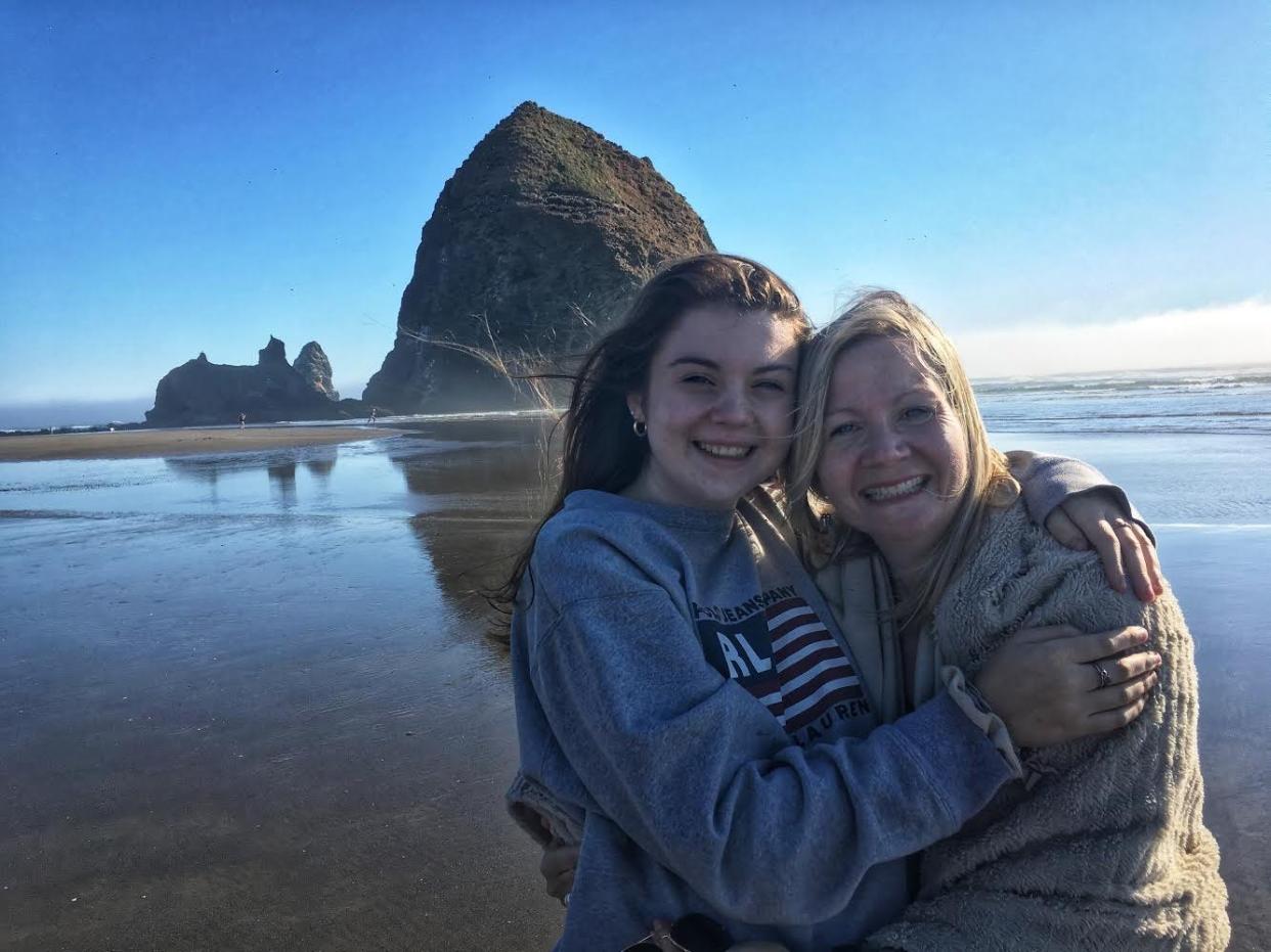 Zoey Steel (left) and her mother (right) on a beach in front of a rock