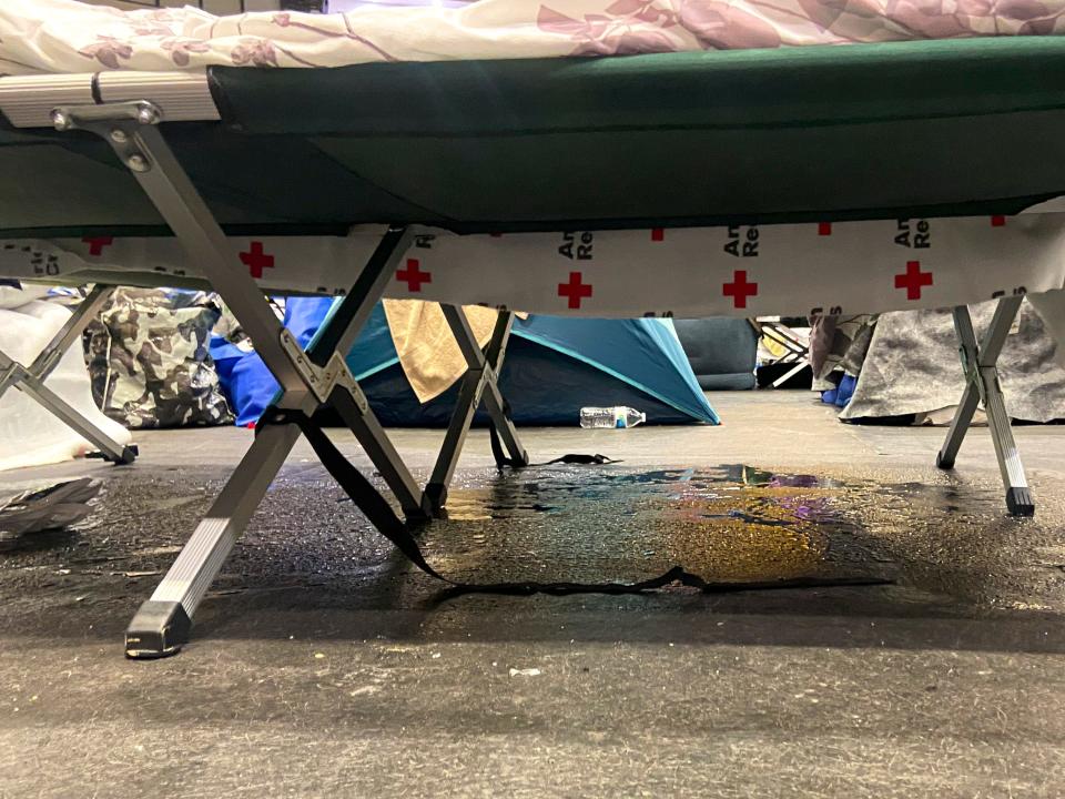 Water seeps through boards covering melting ice below a sleeping cot in the Hertz Arena in Estero, Fla., on Thursday, Oct. 14, 2022. "At night they completely turn the temperature all the way down and so the moisture that you see underneath each bed turns into a sheet of ice," said Brittany Allen, a mother of seven staying in the rink with her family who lived in North Fort Myers.