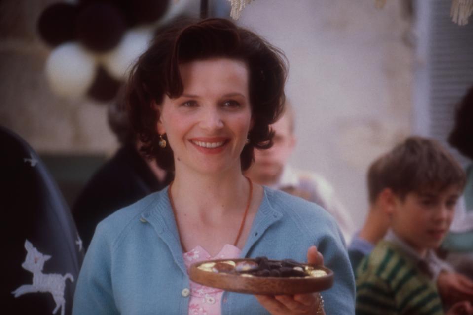 woman holding out a plate of chocolates