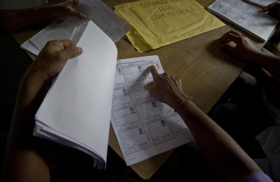 Villagers check their names in the final list of the National Register of Citizens (NRC) at an NRC center in Buraburi village in Morigaon district, in the northeastern Indian state of Assam, Saturday, Aug. 31, 2019. India has published the final citizenship list in the Indian state of Assam, excluding nearly two million people amid fears they could be rendered stateless. The list, known as the National Register of Citizens (NRC), intends to identify legal residents and weed out illegal immigrants from the state. (AP Photo/Anupam Nath)