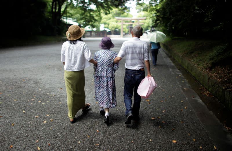 FILE PHOTO: An elderly woman is led to a temple in Tokyo in this July 17, 2009 file photo