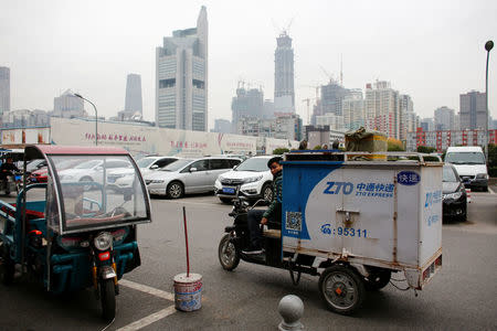 A man drives a vehicle of the ZTO Express delivery service near the Central Business District in Beijing, China, October 27, 2016. REUTERS/Thomas Peter