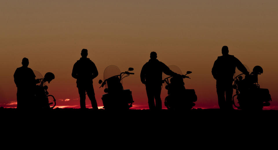 In this May 28, 2013 photo, four riders stand next to their motorcycles and watch the sun set near Broken Hill 1,160 kilometers (720 miles) from Sydney, Australia, during a seven-day, 3,000-kilometer (1,900-mile) journey across the Outback. (AP Photo/Rob Griffith)