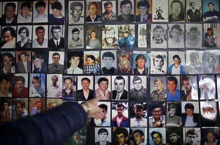 Hajra Catic points at the picture of her husband that is among pictures of victims of the genocide in Tuzla, December 23, 2014. Catic lost her husband and 20 other relatives in the worst massacre on European soil since the World War Two. REUTERS/Dado Ruvic