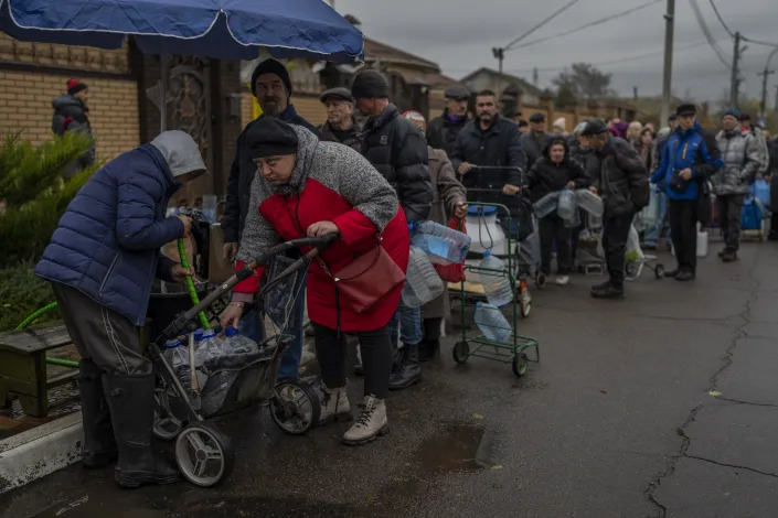 FILE - Residents queue to fill containers with drinking water in Kherson, southern Ukraine, Sunday, Nov. 20, 2022. The Russian withdrawal from the only provincial capital it gained in nine months of war was one of Moscow most significant battlefield losses. Now that its troops hold a new front line, the Ukrainian military said through a spokesman, the army is planning its next move.(AP Photo/Bernat Armangue, File)