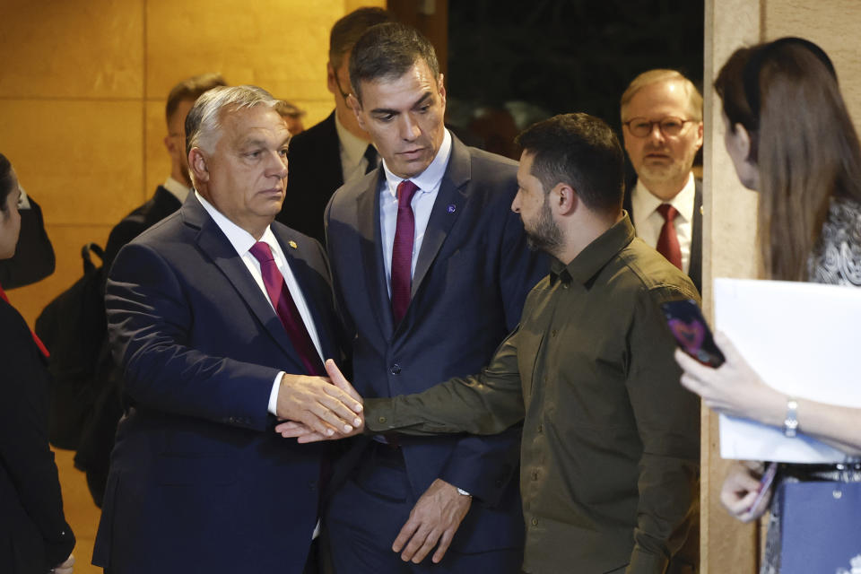 Viktor Orban, left, Prime Minister of Hungary, and Volodymyr Zelenskyy, right, President of Ukraine, shake hands beside Spain's Prime Minister Pedro Sanchez, center, prior to the opening ceremony at the European Political Community (EPC) Summit at the Congress Hall in Granada, Spain, Thursday, Oct. 5, 2023. (Peter Klaunzer/Keystone via AP)