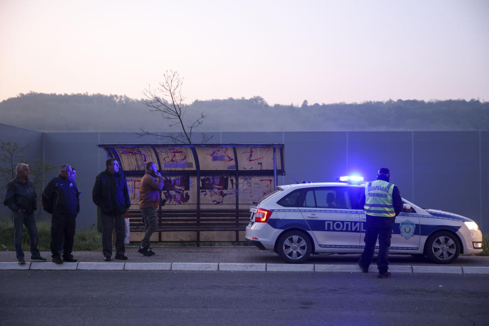 Police officers block the road near the village of Mali Pozarevac, some 50 kilometers (30 miles) south of Belgrade, Serbia, Friday, May 5, 2023. A shooter killed at least eight people and wounded 13 in a drive-by attack near a town close to Belgrade late Thursday, the second such mass killing in Serbia in two days, state television reported. (AP Photo/Armin Durgut)