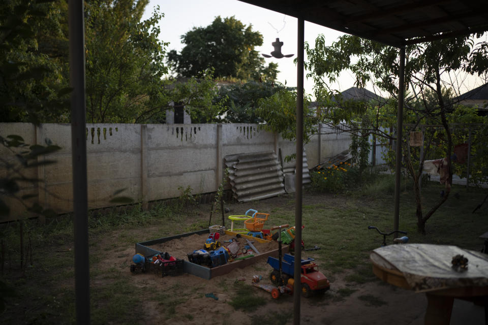 Children's toys are lying in and around a sandbox outside Natalia Rosolova's home in Kupiansk-Vuzlovyi, Ukraine, Wednesday, Aug. 23, 2023. Residents close to the northeast frontline are ignoring calls from Ukrainian authorities to evacuate as the fighting inches closer. (AP Photo/Bram Janssen)