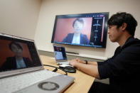 Naruhiko Ito, assistant brand manager of Brand Shiseido Group, demonstrates Shiseido released AR makeup filter for men to use for online meetings in Tokyo Thursday, April 15, 2021. A large personal care company, Shiseido, says one of its male makeup lines has seen double-digit growth during the coronavirus pandemic. Company officials give a similar reason: Men, confronted with the sight of their faces repeatedly during online meetings, want to improve what they see. (AP Photo/Eugene Hoshiko)