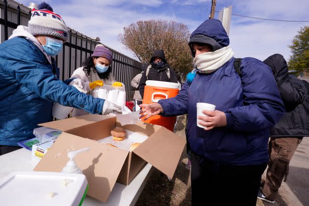 Members of the Templo de Celebration of Decatur, Texas, hand out food and warm drinks Friday outside a warming center in Fort Worth.