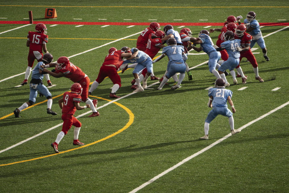 The Lahainaluna High School football junior varsity team plays against Baldwin High School at Sue D. Cooley Stadium, Saturday, Oct. 21, 2023, in Lahaina, Hawaii. Lahainaluna’s varsity and junior varsity football teams are getting back to normal since the devastating wildfire in August. (AP Photo/Mengshin Lin)