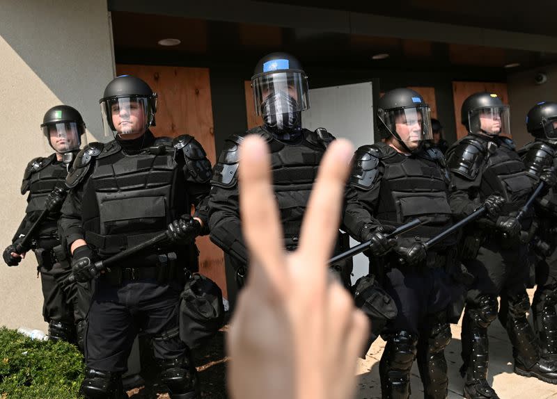 Adam Andrew Salgado sostiene un cartel mientras la policía mantiene un perímetro en Kenosha, Wisconsin, EEUU, el 24 de agosto de 2020