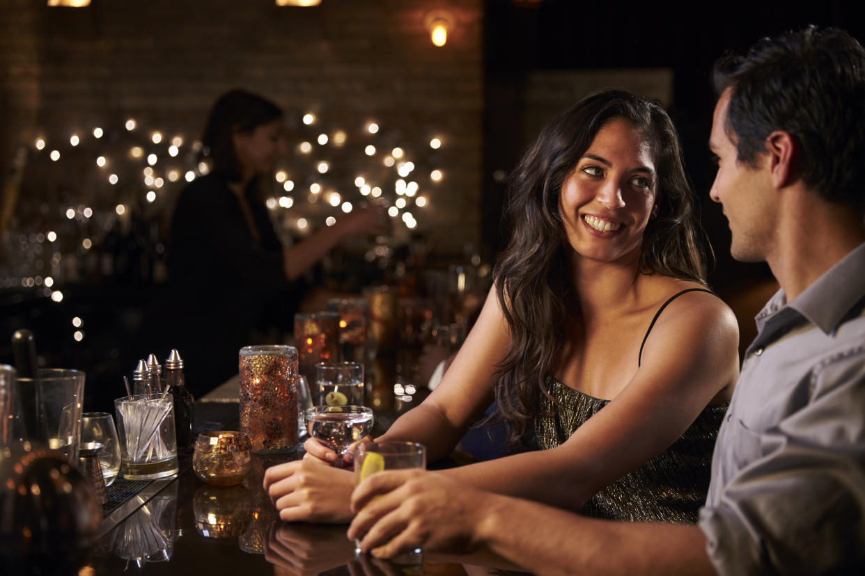 A couple enjoying a night out at cocktail bar. (PHOTO: Getty Images)