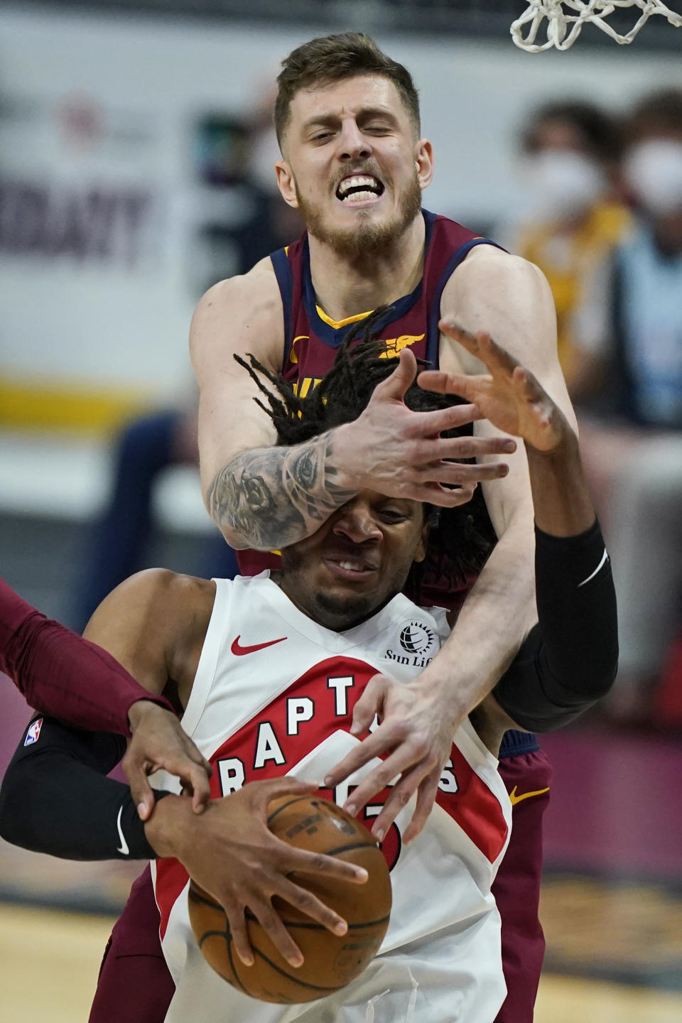 Cleveland Cavaliers Isaiah Hartenstein, top, knocks the ball loose from Toronto Raptors' Freddie Gillespie in the first half of an NBA basketball game, Saturday, April 10, 2021, in Cleveland. (AP Photo/Tony Dejak)