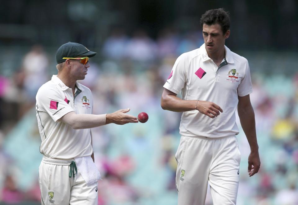 Australia's David Warner, left, tosses the ball to teammate Mitchell Starc during their cricket test match against Pakistan in Sydney, Australia, Saturday, Jan. 7, 2017. (AP Photo/Rick Rycroft)