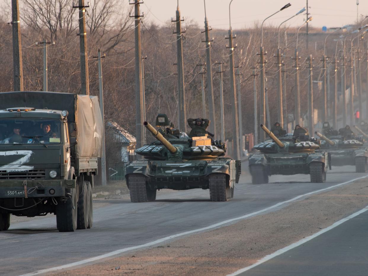 A column of tanks marked with the Z symbol stretches into the distance as they proceed northwards along the Mariupol-Donetsk highway.